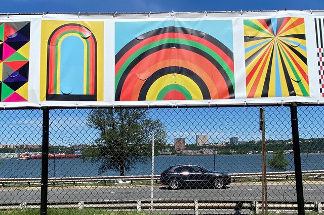 Riverside Park art mural with rainbows and bold colors, with a car on the highway in the background